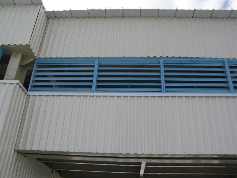 Acercamiento a louvers azules que forman parte de la ventilación de una industria